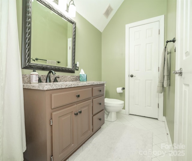 bathroom featuring vaulted ceiling, tile patterned flooring, vanity, toilet, and baseboards