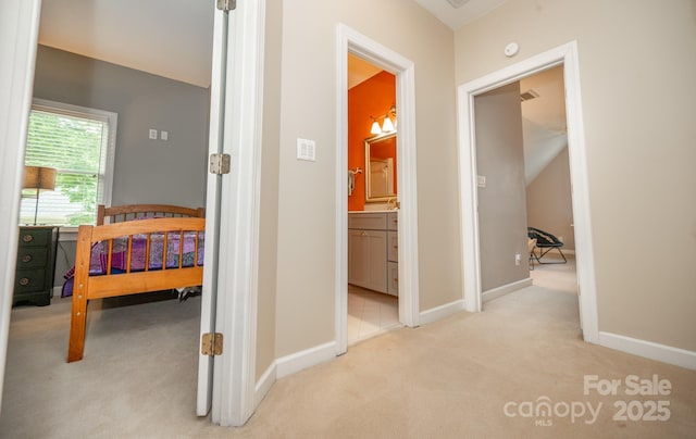 corridor featuring light carpet and baseboards