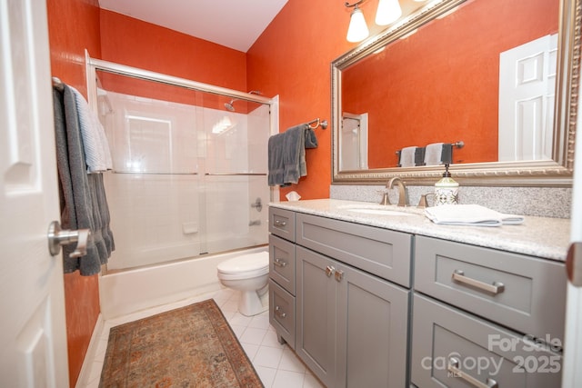 bathroom with tile patterned flooring, vanity, toilet, and enclosed tub / shower combo