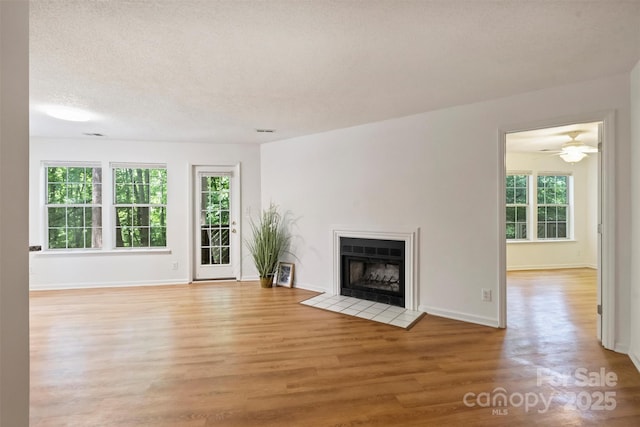 6016 Gray Gate Ln Unit C, Charlotte, NC 28210 - unfurnished living room featuring light wood-style flooring, a fireplace with flush hearth, baseboards, and ceiling fan