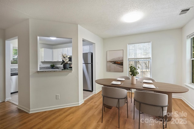 6016 Gray Gate Ln Unit C, Charlotte, NC 28210 - dining room with light wood-type flooring, healthy amount of natural light, a textured ceiling, and baseboards