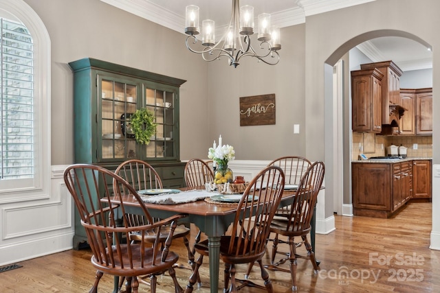 309 Palm Cove Way, York, SC 29745 - dining area with arched walkways, ornamental molding, light wood-style flooring, healthy amount of natural light, and a chandelier