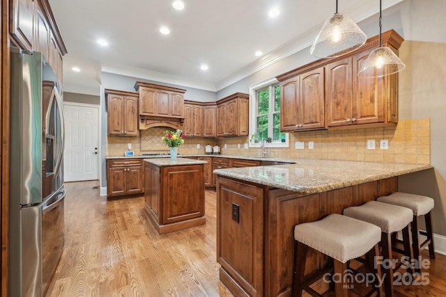 309 Palm Cove Way, York, SC 29745 - kitchen featuring appliances with stainless steel finishes, a peninsula, wood finished floors, ornamental molding, and a breakfast bar area