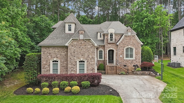 309 Palm Cove Way, York, SC 29745 - french country style house featuring a front yard, central AC, brick siding, and a shingled roof