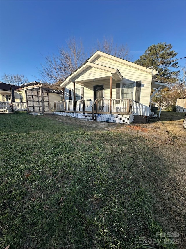 rear view of property with a lawn and a porch