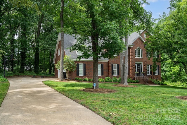 view of front of property with a front lawn, driveway, and brick siding