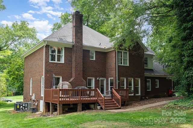 rear view of house with a wooden deck, a yard, a shingled roof, cooling unit, and brick siding