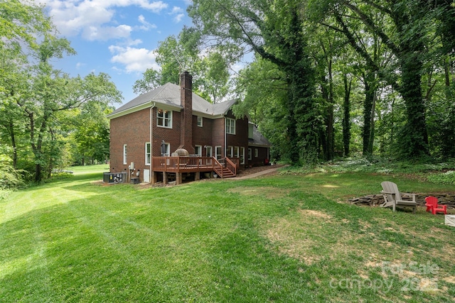 view of grassy yard with a wooden deck and central AC