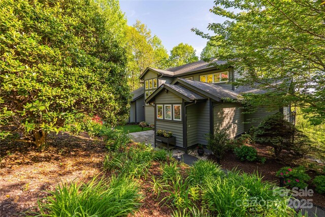 view of side of property featuring a shingled roof