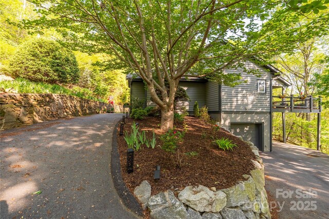 view of front facade featuring asphalt driveway and a garage