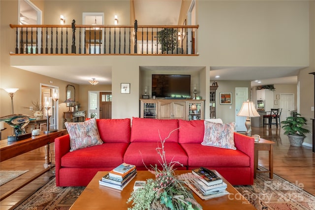 living room with wood finished floors and a high ceiling
