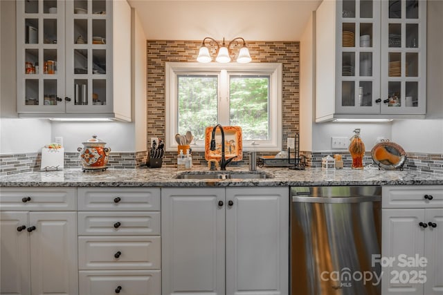 bar with dishwasher, a sink, decorative backsplash, and a chandelier