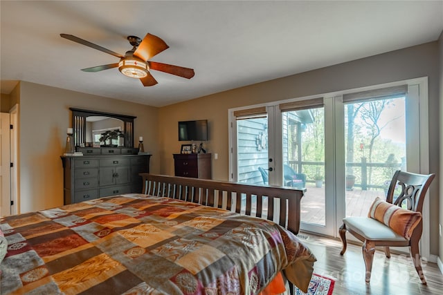 bedroom featuring access to outside, wood finished floors, a ceiling fan, and french doors