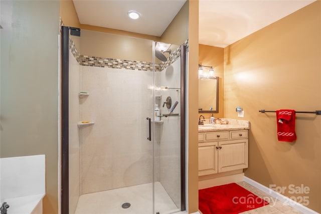 bathroom featuring a stall shower, vanity, baseboards, and tile patterned flooring