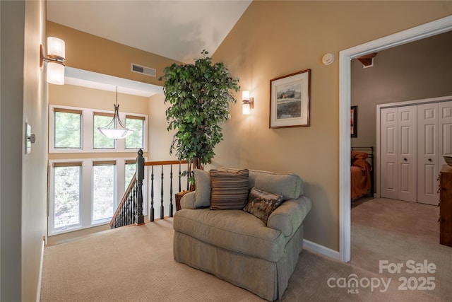 sitting room with carpet flooring, vaulted ceiling, an upstairs landing, and baseboards