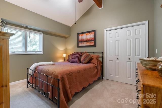 bedroom with light colored carpet, a closet, beamed ceiling, baseboards, and ceiling fan