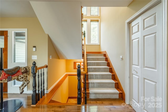 stairway with wood finished floors and baseboards