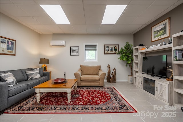 tiled living room featuring an AC wall unit and a drop ceiling