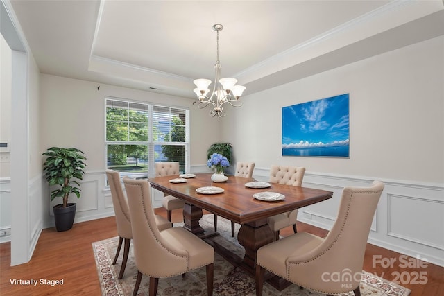 9230 Loch Glen Way, Charlotte, NC 28278 - dining space with a decorative wall, a chandelier, light wood finished floors, crown molding, and a raised ceiling