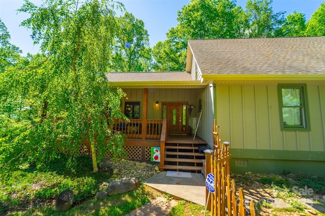 view of front of home with roof with shingles, board and batten siding, and covered porch