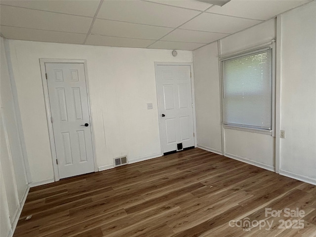 2009 Hickory Grove Rd, Gastonia, NC 28056 - unfurnished bedroom featuring a drop ceiling, dark wood-type flooring, and baseboards