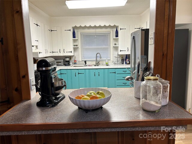 2009 Hickory Grove Rd, Gastonia, NC 28056 - kitchen with open shelves, a sink, freestanding refrigerator, and blue cabinetry