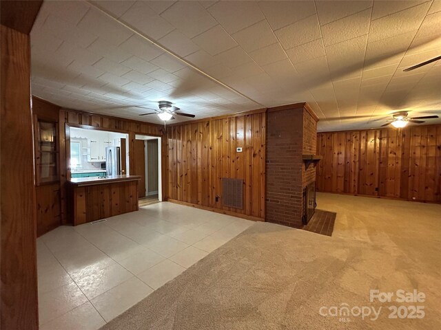 2009 Hickory Grove Rd, Gastonia, NC 28056 - unfurnished living room with a ceiling fan, wooden walls, and a fireplace