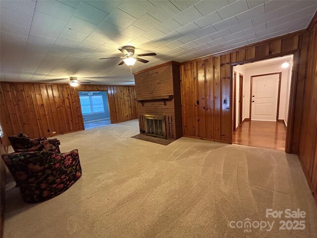 2009 Hickory Grove Rd, Gastonia, NC 28056 - unfurnished living room with wooden walls, ceiling fan, carpet, and a brick fireplace