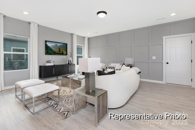 living area featuring a decorative wall and light wood finished floors