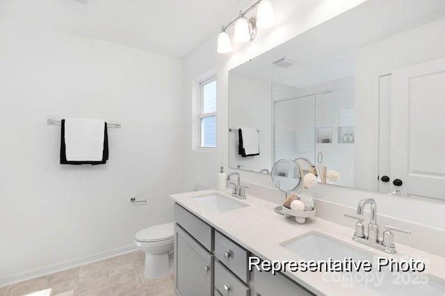 bathroom featuring a stall shower, toilet, baseboards, and double vanity