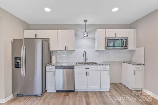 2511 Linwood Rd, Gastonia, NC 28052 - kitchen featuring appliances with stainless steel finishes, a sink, light wood-style floors, light stone countertops, and recessed lighting