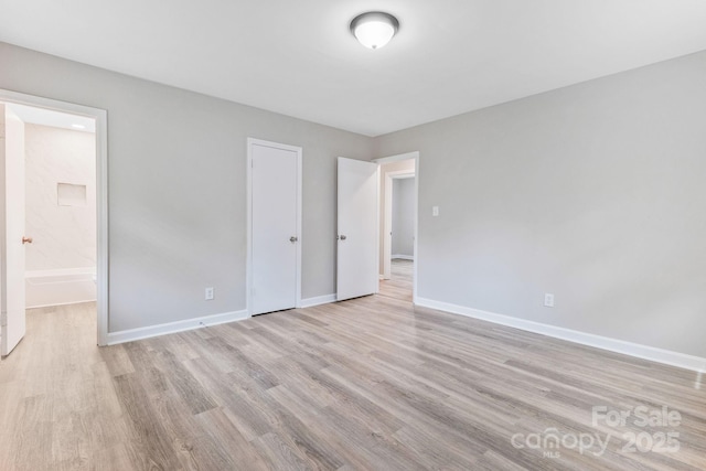 2511 Linwood Rd, Gastonia, NC 28052 - unfurnished bedroom featuring light wood-style floors, baseboards, and connected bathroom