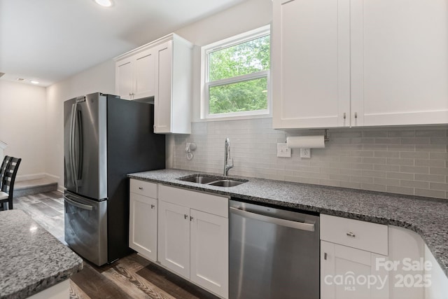 7308 Rothmore St, Charlotte, NC 28215 - kitchen featuring appliances with stainless steel finishes, a sink, dark wood finished floors, white cabinetry, and backsplash