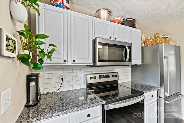 kitchen featuring appliances with stainless steel finishes, a textured ceiling, white cabinets, and tasteful backsplash