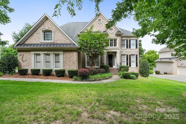 9433 Wallace Pond Dr, Huntersville, NC 28078 - view of front of home featuring a standing seam roof, brick siding, a front yard, and metal roof
