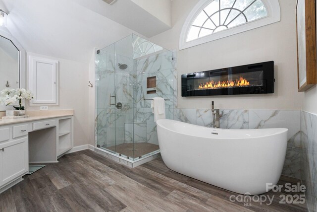9433 Wallace Pond Dr, Huntersville, NC 28078 - bathroom featuring a freestanding bath, a marble finish shower, vanity, tile walls, and wood finished floors