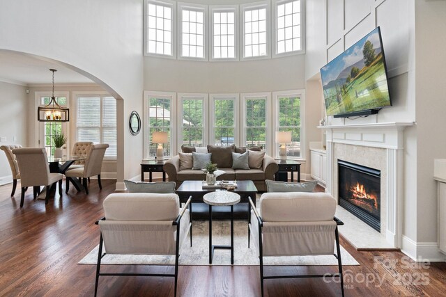 9433 Wallace Pond Dr, Huntersville, NC 28078 - living room featuring arched walkways, wood finished floors, a fireplace, healthy amount of natural light, and a towering ceiling