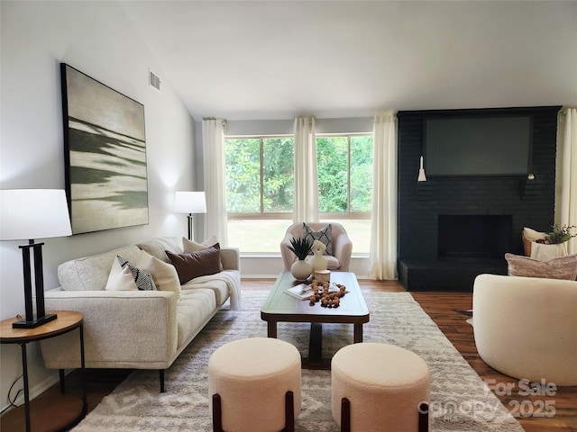 7228 Rollingridge Dr, Charlotte, NC 28211 - living room featuring wood finished floors, a brick fireplace, and vaulted ceiling