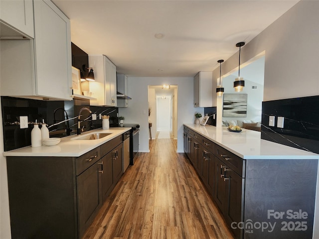 7228 Rollingridge Dr, Charlotte, NC 28211 - kitchen with a sink, wood finished floors, a peninsula, light countertops, and decorative backsplash