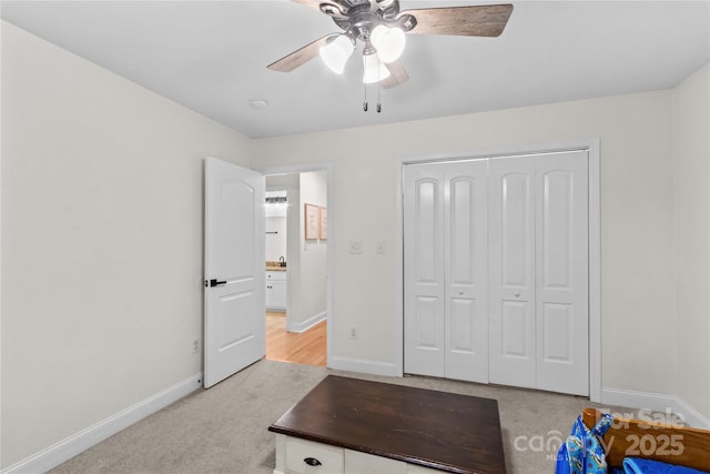 unfurnished office featuring baseboards, light carpet, and a ceiling fan