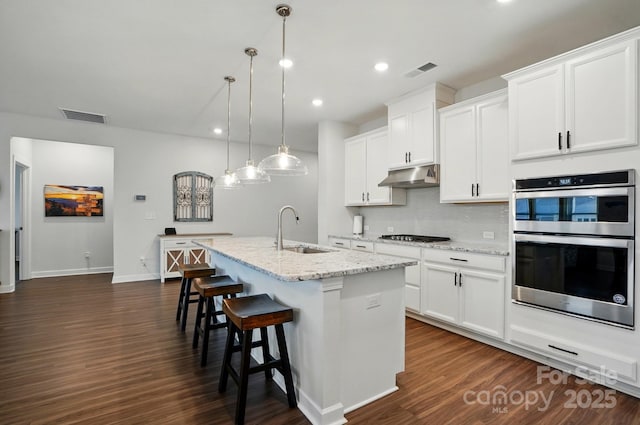 1825 Lotus Ln, Denver, NC 28037 - kitchen featuring under cabinet range hood, a sink, a kitchen island with sink, dark wood finished floors, and recessed lighting