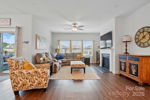 1825 Lotus Ln, Denver, NC 28037 - living area with dark wood-type flooring, a ceiling fan, a glass covered fireplace, and baseboards