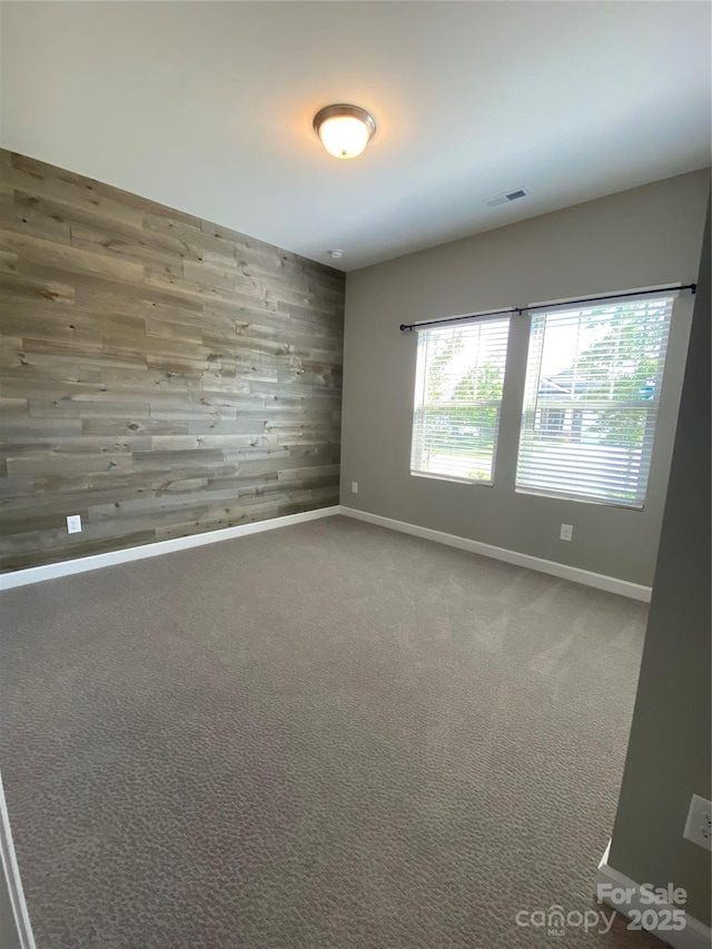 1825 Lotus Ln, Denver, NC 28037 - spare room featuring wooden walls, baseboards, carpet floors, and an accent wall