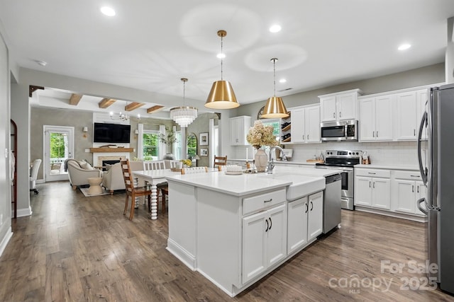 4842 Durneigh Dr, Kannapolis, NC 28081 - kitchen featuring appliances with stainless steel finishes, open floor plan, backsplash, white cabinetry, and recessed lighting