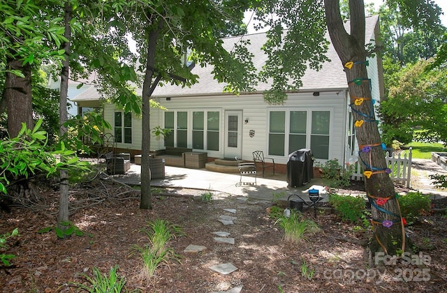 back of house featuring a patio and a shingled roof