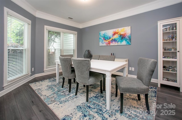 dining room featuring crown molding, wood finished floors, and baseboards
