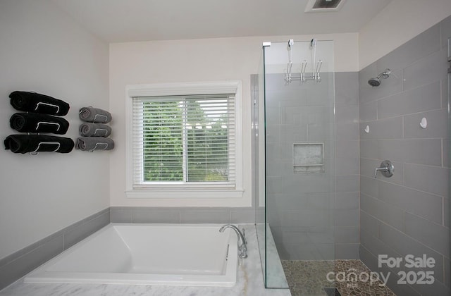 full bathroom featuring a tile shower and a garden tub