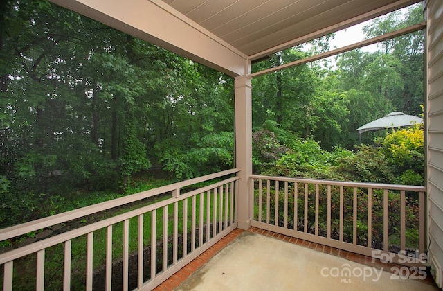 balcony featuring a porch and a forest view