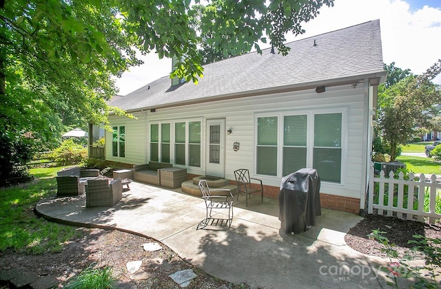 rear view of property with a patio area, fence, and roof with shingles