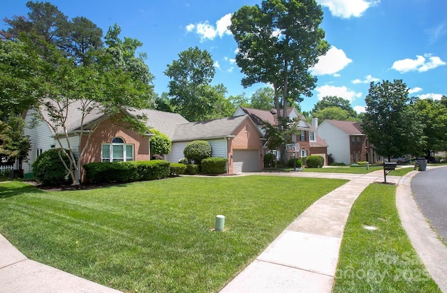 view of property hidden behind natural elements with a garage, concrete driveway, a front lawn, and a residential view